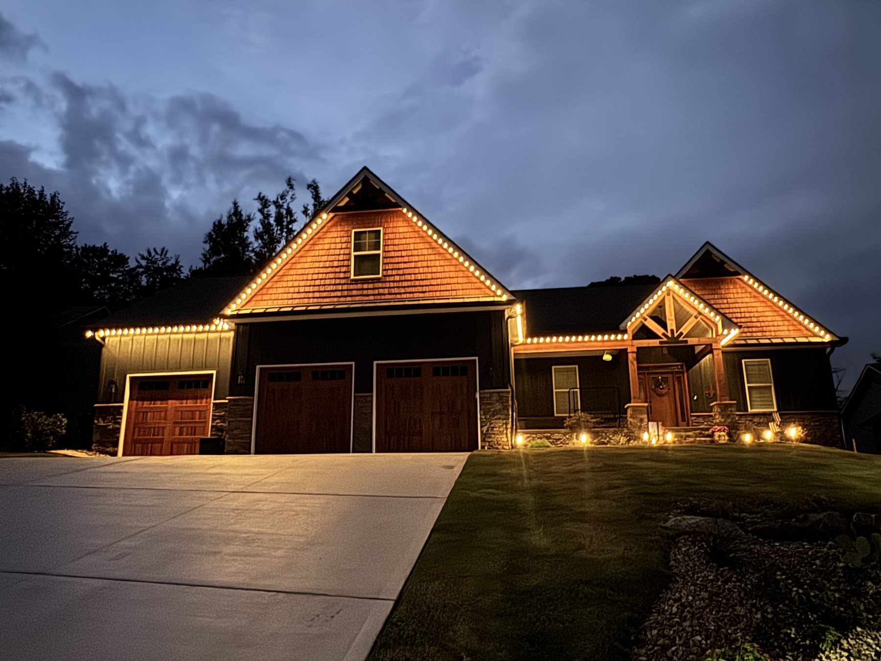 EverLume permanent lighting tracing timber gables at dusk, front entry view